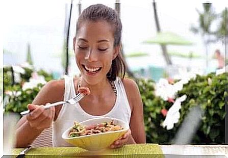 A young woman eating a salad with tuna. 